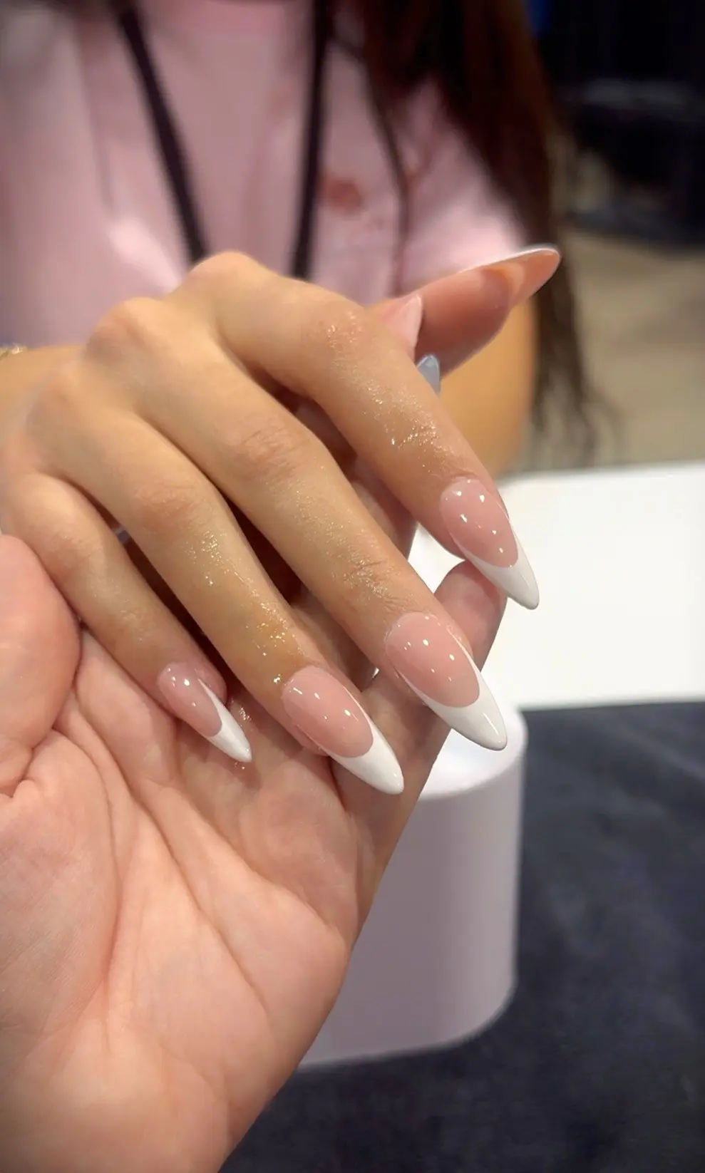 Uñas acrílicas forma almendra con punta francesa blanca, trabajo de estudiante de tecnología de uñas en expo