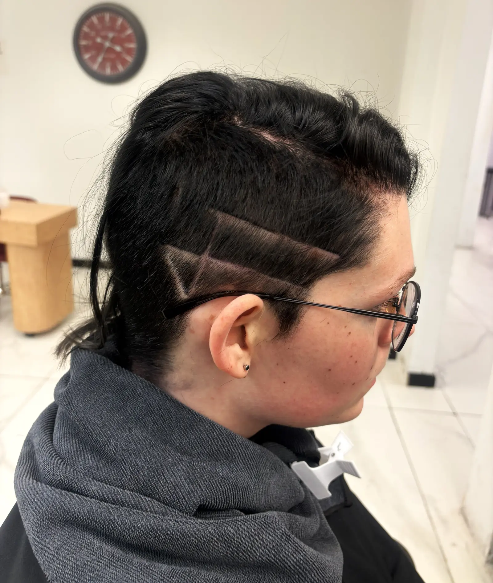 Diseño geométrico rapado en patrón de corte, práctica de estudiante de cosmetología