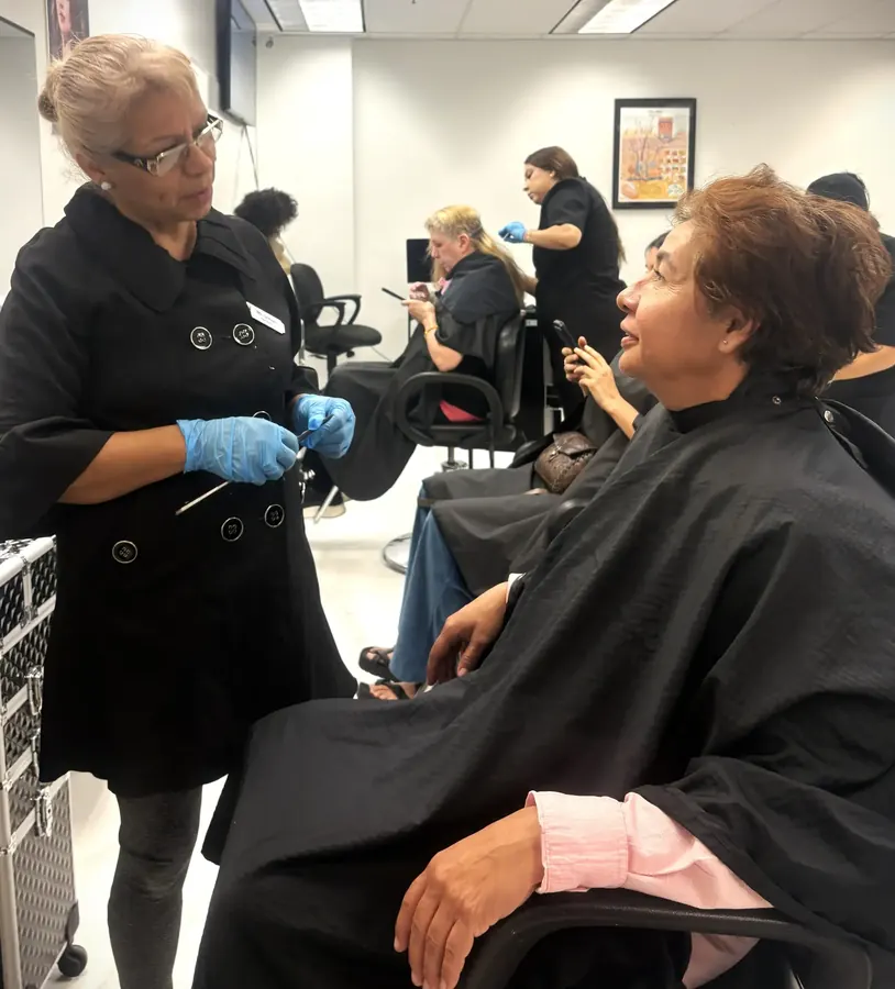 Instructora de cosmetología trabajando con una estudiante en la clínica